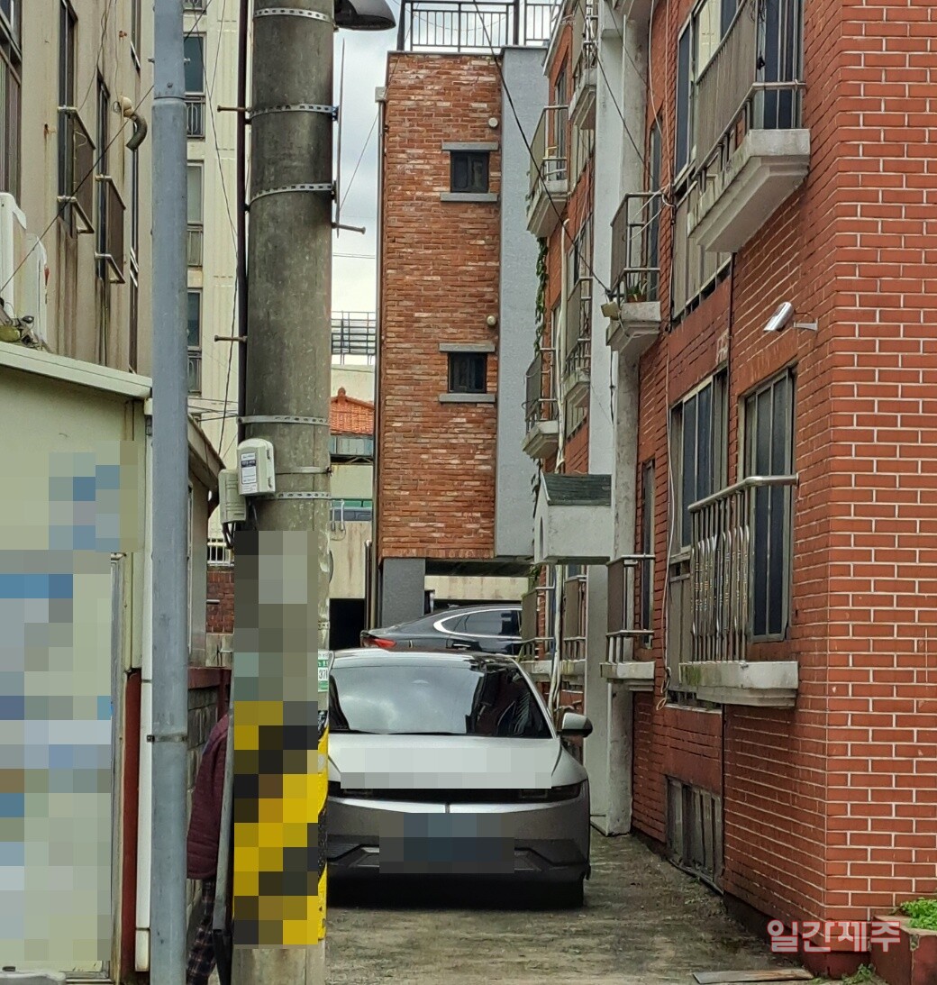 ▲ 제주시 노형동에 위치한 다세대주택 주차 출입구를 1/3이상 막고 있는 전신주...이에 대한 세대주들은 몇번 한전에 원활한 주차장 진입확보를 위해 민원을 넣었으나 한전 측의 대응은 일괄적 외면이었다.ⓒ일간제주