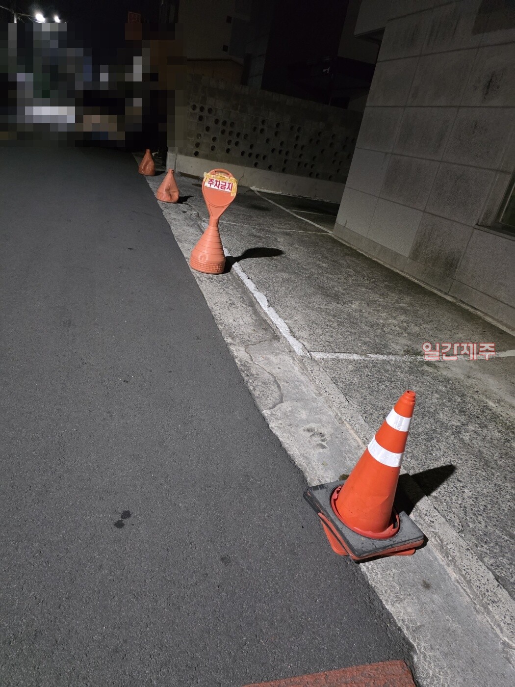 ▲ 노형쪽 대단위 아파트 단지 맞은편에 위치한 A건물은 심야에 건물에 차를 세우지 못하도록 적재물을 올려놓고 있다. 자신의 건물주차공간이 아닌 일반 도로에까지 마구 설치해 민원이 제기되고 있다.ⓒ일간제주